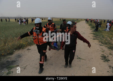 I medici hanno visto che trasporta un manifestante ferito durante gli scontri. I dimostranti palestinesi si sono scontrati con le forze israeliane nella scia di un milione di forte protesta sul terreno, rivendicano il diritto di tornare in patria al confine tra Israele e la striscia di Gaza in Khan Yunis nel sud della striscia di Gaza. Il Ministero della Sanità in Hamas-eseguire detto settore tre palestinesi sono stati uccisi dal fuoco israeliano durante gli scontri. Foto Stock