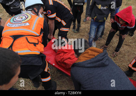 I medici hanno visto che trasporta un manifestante ferito durante gli scontri. I dimostranti palestinesi si sono scontrati con le forze israeliane nella scia di un milione di forte protesta sul terreno, rivendicano il diritto di tornare in patria al confine tra Israele e la striscia di Gaza in Khan Yunis nel sud della striscia di Gaza. Il Ministero della Sanità in Hamas-eseguire detto settore tre palestinesi sono stati uccisi dal fuoco israeliano durante gli scontri. Foto Stock