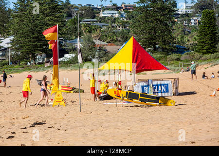 Surf salvataggio volontari sulla spiaggia di Newport a Sydney, Australia con bandiere rosse e gialle spiaggia e tenda ombra Foto Stock