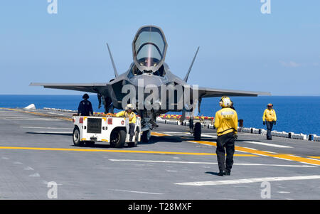 190329-N-OX029-1049 sul Mare del Sud della Cina (29 marzo 2019) - i marinai e Marines taxi un F-35B Lightning II aeromobili assegnati alle Marine Fighter Attack Squadron (VMFA) 121 sul ponte di volo dell'assalto anfibio nave USS Wasp (LHD 1). Wasp, ammiraglia di Vespa Anfibia Gruppo pronto, è operativo nell'Indo-Pacifico regione per migliorare l'interoperabilità con i partner e servire come una letale, pronto a forza di risposta per qualsiasi tipo di emergenza. (U.S. Foto di Marina di Massa lo specialista di comunicazione di terza classe Benjamin F. Davella III) Foto Stock