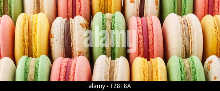 Righe di colorati macarons francese - verde, giallo e rosa. Creative banner web. Foto Stock