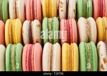 Righe di colorati macarons francese - verde, giallo e rosa. Background creativo. Foto Stock