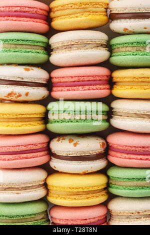 Righe di colorati macarons francese. Background creativo. Vista dall'alto. Foto Stock