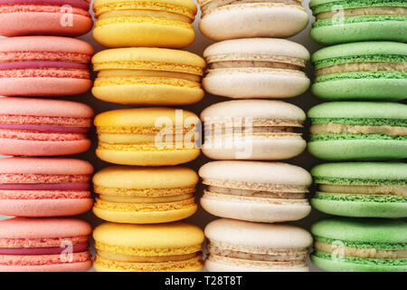Righe di colorati macarons francese. Background creativo. Vista dall'alto. Foto Stock