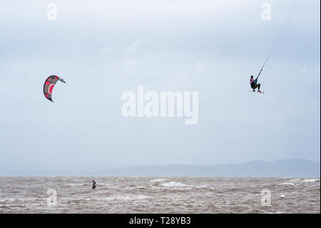 Kite-surf e kite boarder ottenere alcuni aria sulla baia di Morecambe, Inghilterra. Foto Stock