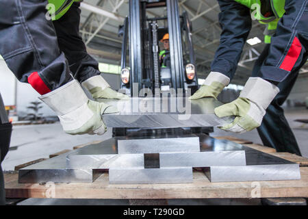 Assunzione di lavoratori per billette di alluminio a macchina CNC shop Foto Stock