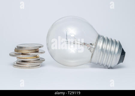 Lampadina con mucchio di monete delle scale per il piano finanziario o business idea concetto - Imagen Foto Stock