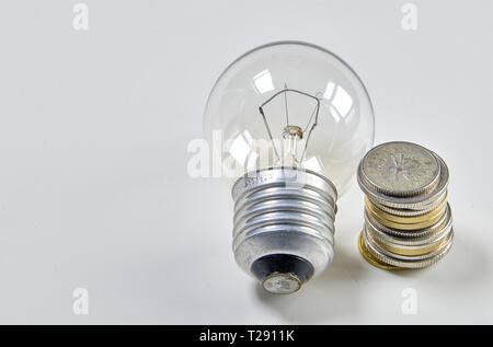 Lampadina con mucchio di monete delle scale per il piano finanziario o business idea concetto - Imagen Foto Stock