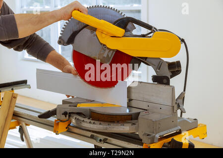 Operatore Taglia legno zoccolo sulla potenza troncatrice nuova casa prima di installare Foto Stock