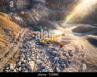 Vista panoramica al tramonto della cava di ghiaia,mining di costruzione gialla ghiaia, ghiaia di pompaggio con l aiuto di potenti pompe, post-apocalittico landscapе Foto Stock