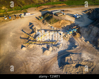 Vista panoramica al tramonto della cava di ghiaia,mining di costruzione gialla ghiaia, ghiaia di pompaggio con l aiuto di potenti pompe, post-apocalittico landscapе Foto Stock