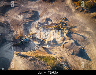 Vista panoramica al tramonto della cava di ghiaia,mining di costruzione gialla ghiaia, ghiaia di pompaggio con l aiuto di potenti pompe, post-apocalittico landscapе Foto Stock