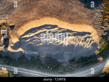 Vista panoramica al tramonto della cava di ghiaia,mining di costruzione gialla ghiaia, ghiaia di pompaggio con l aiuto di potenti pompe, post-apocalittico landscapе Foto Stock