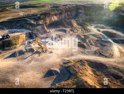 Vista panoramica al tramonto della cava di ghiaia,mining di costruzione gialla ghiaia, ghiaia di pompaggio con l aiuto di potenti pompe, post-apocalittico landscapе Foto Stock