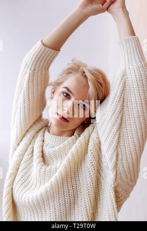 Dark-eyed attraente donna stretching le braccia al mattino Foto Stock