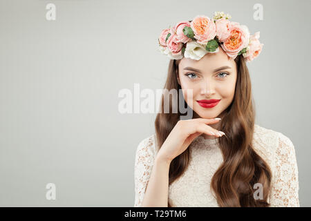 Bella donna in estate ghirlanda di fiori. Grazioso modello con labbra rosse e trucco carino sorriso ritratto Foto Stock