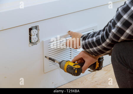 L uomo è di installare la parete del coperchio sfiato ventilazione manutenzione opere di riparazione rinnovamento nella nuova casa prima di installare Foto Stock