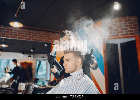 Elegante uomo seduto in una barberia Foto Stock