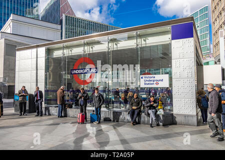 Persone fuori dall'ingresso della stazione della metropolitana Victoria a Cardinal Walk , Londra, Regno Unito Foto Stock