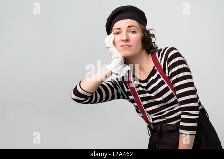 Carino giovane donna mime in posa di essere triste e sconvolto. Studio shoot. Negativo emozione per il viso Foto Stock