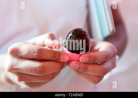KATA - peeling delle mani di un secolo uovo al mercato di Kata. Il nero verdastro Duck egg che viene conservato per diverse settimane in argilla è una prelibatezza cinese Foto Stock