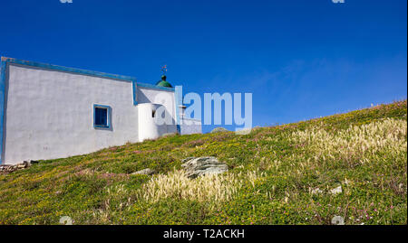 La Grecia. Kea Island Lighthouse. Colore bianco edificio, coloratissimi fiori selvatici su erba verde, blu cielo chiaro sfondo Foto Stock