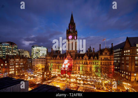 Presto la sera notte a Manchester centro città tedesca europea Mercatini di Natale 2018 incorniciata da pietra miliare town hall e Albert Square Foto Stock