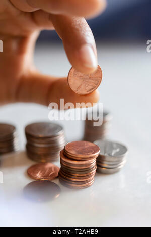 Mano di donna monete di impilamento Foto Stock