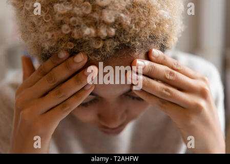 Donna con mal di testa sulla fronte di sfregamento Foto Stock