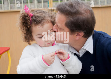 Uomo di baciare la figlia sulla guancia Foto Stock
