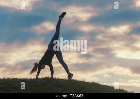 Giovane donna facendo appoggiate sull'erba mattina allenamento bellissima alba Foto Stock