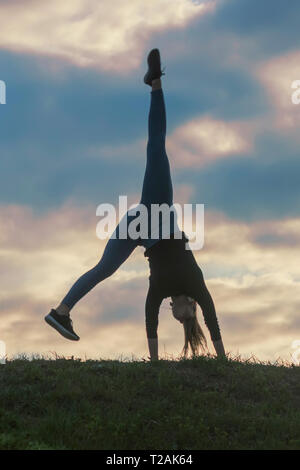 Giovane donna facendo appoggiate sull'erba mattina allenamento bellissima alba Foto Stock