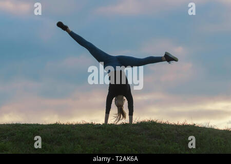 Giovane donna facendo appoggiate sull'erba mattina allenamento bellissima alba Foto Stock