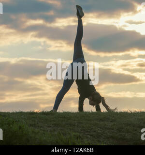 Giovane donna facendo appoggiate sull'erba mattina allenamento bellissima alba Foto Stock