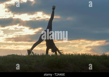 Giovane donna facendo appoggiate sull'erba mattina allenamento bellissima alba Foto Stock