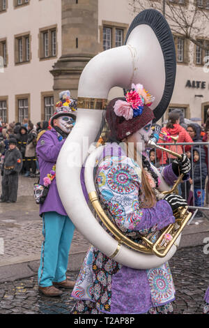 STUTTGART, Germania - 5 Marzo: femmina tubista in marching band con musicisti vestito come zombie in parata sotto una leggera pioggia. Girato a Carnevale Foto Stock