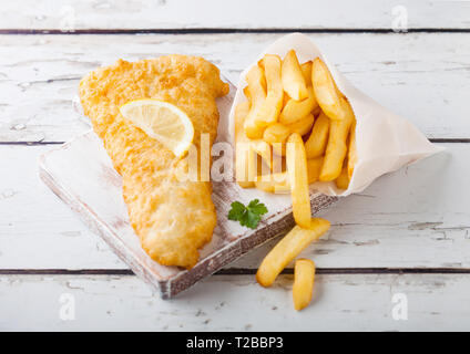 Britannico tradizionale pesce e patatine con salsa tartara sul tagliere in legno bianco sullo sfondo. Foto Stock