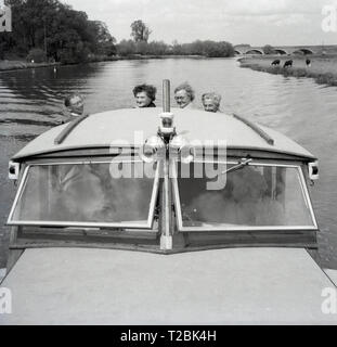 Degli anni Cinquanta, storico, due coppie mature su un motore di lancio o cabina crusier scendendo lungo il corso del fiume Tamigi a Oxford, Inghilterra, Regno Unito. Foto Stock
