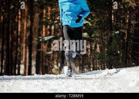 Gambe runner atleta che corre nella neve sentiero invernale Foto Stock