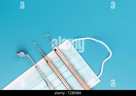 Dentista attrezzature mediche strumenti in studio dentistico su sfondo blu. Foto Stock