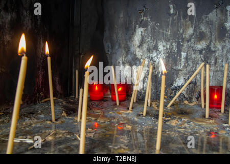 Molte candele accese in chiesa in un posto speciale per commemorare Foto Stock