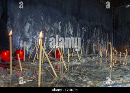 Molte candele accese in chiesa in un posto speciale per commemorare Foto Stock