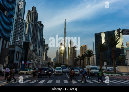 Pedoni che attraversano la strada in business bay nei pressi di Dubai Burj Khalifa Foto Stock