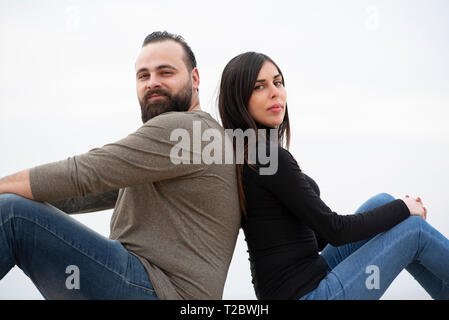 Me e donna seduta di schiena sulla spiaggia Foto Stock