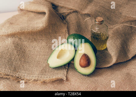 Ancora la vita di olio di oliva e avocado per cheto dieta su ruvida tela di canapa Foto Stock