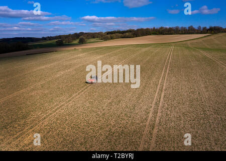 Trattore concime spargimento sul campo dal di sopra con Drone ,l'Inghilterra,UK Foto Stock