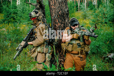 Soffice come l'aria uomini con pistole di stand di schiena. Soldati stand sulla collina e su chiamata nella foresta Foto Stock