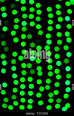 Abstract non focalizzato bokeh di fondo verde su sfondo nero. sfocati e sfocato numerose rotonde luce. Foto Stock