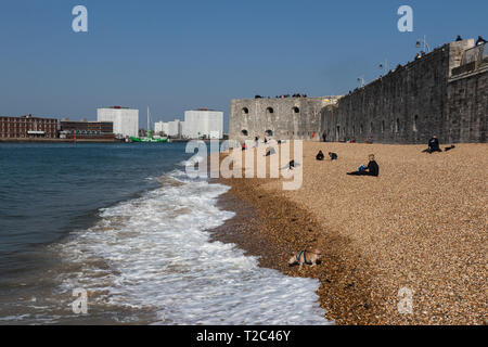 Persone relxing sulla spiaggia di ciottoli a pareti calde, Old Portsmouth, Regno Unito Foto Stock