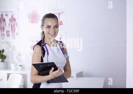 Un giovane medico donna a una scrivania in ufficio. Il concetto di salute e medicina. Foto Stock